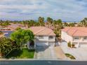 Stunning aerial view of a two-story home, with a terra cotta roof, lush lawn and desert landscaping at 1430 October Oak Ave, Las Vegas, NV 89123