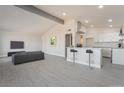 Bright, open-concept living room featuring wood-look floors and eat-in kitchen with a breakfast bar at 1720 Hassett Ave, Las Vegas, NV 89104