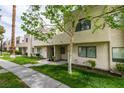 Townhouse exterior featuring a sidewalk, trimmed green lawn, and mature trees providing shade at 2681 Ruthe Duarte Ave, Las Vegas, NV 89121