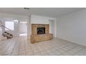 Spacious living room with a cozy brick fireplace and tiled flooring; awaiting your personal touch at 2681 Ruthe Duarte Ave, Las Vegas, NV 89121