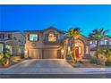 Charming two-story home with landscaped yard, swaying palm trees, and a spacious three-car garage at twilight at 2749 Carolina Blue Ave, Henderson, NV 89052