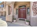 Elegant front entry with double doors, arched transom window, and decorative sconces at 2749 Carolina Blue Ave, Henderson, NV 89052