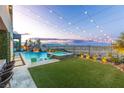 Beautiful backyard featuring a swimming pool with a waterfall, an inset hot tub, an outdoor seating area, and landscape lighting at 286 Shaded Canyon Dr, Henderson, NV 89012