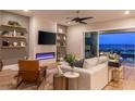 Cozy living room with a modern electric fireplace, floating shelves, comfortable seating, and a view of the backyard at 286 Shaded Canyon Dr, Henderson, NV 89012