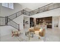 Expansive living room boasts a staircase, kitchen view, and elegant railings overlooking the open space at 350 Gandara St, Las Vegas, NV 89138
