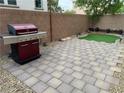 Paver patio with synthetic grass featuring a stainless steel grill, surrounded by a block wall at 355 Gracious Way, Henderson, NV 89011