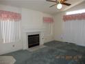 Open living room featuring a cozy fireplace, ceiling fan, and natural light at 5912 Wabusca Way, Las Vegas, NV 89142