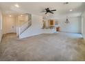 Spacious open-concept space with stairs to the second story and an opening into the kitchen at 7011 Overton St, Las Vegas, NV 89166