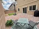 Cozy brick-paved patio area with outdoor seating and a grill, perfect for entertaining in the backyard at 7041 Fossil Rim St, North Las Vegas, NV 89084