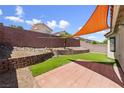 Landscaped backyard featuring low-maintenance turf and a covered patio area at 7441 Aurora Glow St, Las Vegas, NV 89139