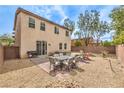 Backyard with a patio area, a built-in fire pit, a hot tub, desert landscaping, and a privacy fence at 7898 Red Rock Ridge Ave, Las Vegas, NV 89179