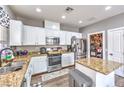 Well-lit kitchen featuring granite countertops, stainless steel appliances, white cabinets, and a pantry at 7898 Red Rock Ridge Ave, Las Vegas, NV 89179