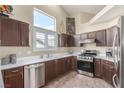 Well-equipped kitchen boasts stainless steel appliances, dark wood cabinets, and sleek countertops at 805 Blue Springs Dr, Henderson, NV 89002