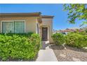 Inviting front entrance with lush landscaping and a secure screen door at 8141 Guava Nectar Ave, Las Vegas, NV 89131