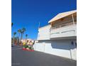 Two story home with covered balcony, dual white garage doors, desert landscaping and clear blue sky at 8452 Boseck Dr # 216, Las Vegas, NV 89145