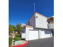 The townhouse has three garage doors and a small side patio at 8452 Boseck Dr # 216, Las Vegas, NV 89145