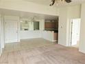 View of living room featuring carpet, tile flooring, and open access to kitchen and dining areas at 8452 Boseck Dr # 216, Las Vegas, NV 89145