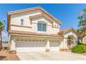 Attractive two-story home featuring a three-car garage, desert landscaping and a light stucco exterior at 9339 Bondeno St, Las Vegas, NV 89123