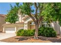 Inviting home featuring a 3-car garage and mature trees in the front yard at 9339 Bondeno St, Las Vegas, NV 89123