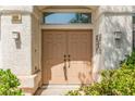 Close-up of the home's double-door entryway, highlighted by modern sconces and decorative bushes at 9339 Bondeno St, Las Vegas, NV 89123