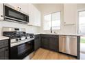 The kitchen features stainless steel appliances, white quartz countertops, and shaker style cabinets at 1069 Silver Bullet Ct, Henderson, NV 89011