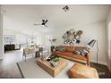 Spacious living room with a tan sofa, decorative wall art, and a ceiling fan at 1069 Silver Bullet Ct, Henderson, NV 89011