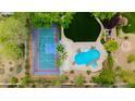 Aerial view of a backyard featuring a basketball court, lush landscaping, pool, and spa at 10726 Hawes End Ct, Las Vegas, NV 89183