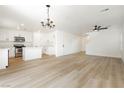 Open-concept living space with wood-look floors, modern lighting, and freshly painted white walls at 1130 Paradise Garden Dr, Henderson, NV 89002