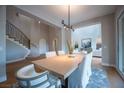 Bright dining room featuring a modern light fixture and staircase, perfect for elegant gatherings at 11359 Winter Cottage Pl, Las Vegas, NV 89135