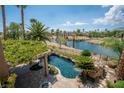 Inviting pool and lush landscaping, enhanced by a scenic lake view in the daytime, making it a serene outdoor oasis at 11359 Winter Cottage Pl, Las Vegas, NV 89135