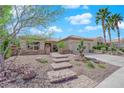 Inviting single-story home featuring stone accents, desert landscaping, and an attractive paved walkway at 2232 Beacon Ridge Dr, Las Vegas, NV 89134
