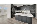 Modern kitchen boasts black cabinets, quartz countertops, stainless steel appliances and large island at 2555 Hampton Rd # 10104, Henderson, NV 89052