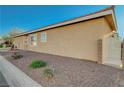 Single-story home with desert landscaping and an access gate between the house and the brick wall at 2852 Red Ct, Las Vegas, NV 89123