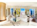 Stylish living room with sleek furniture, a mirrored coffee table, and expansive windows offering city views at 3750 Las Vegas Blvd # 2407, Las Vegas, NV 89158