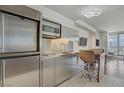 Compact kitchen with stainless steel appliances, modern lighting and breakfast bar with seating at 4381 W Flamingo Rd # 27308, Las Vegas, NV 89103