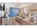 Spacious living room with comfortable sectional, wood-look floors, and access to dining area at 5532 Sentinel Bridge St, Las Vegas, NV 89130