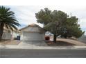 Exterior view of a single story home with an attached two car garage and mature shade trees at 600 Sarajane Ln, Las Vegas, NV 89107
