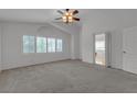 Spacious main bedroom featuring neutral carpet, lots of windows, and a ceiling fan at 6407 Wild Strawberry Ln, Las Vegas, NV 89142