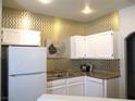 Bright kitchen showcasing white cabinetry, granite countertops, and modern appliances at 6480 Annie Oakley Dr # 111, Las Vegas, NV 89120