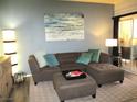 Cozy living room featuring a comfortable sectional sofa, ottoman, and stylish decor at 6480 Annie Oakley Dr # 111, Las Vegas, NV 89120