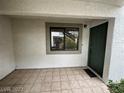 The tiled entryway leads to a dark-green front door and a window, providing a welcoming space at 6749 W Charleston Blvd # 2, Las Vegas, NV 89146