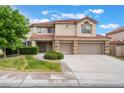Two-story home with a red tile roof and three car garage with manicured front yard and walkway at 7632 Spruce Run Ct, Las Vegas, NV 89128