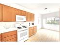 Inviting kitchen with wood cabinetry, white appliances, and ample counter space, ideal for meal preparation at 8120 Backpacker Ct, Las Vegas, NV 89131
