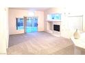 Bright living room with plush carpeting, fireplace, and sliding glass door to backyard at 8120 Backpacker Ct, Las Vegas, NV 89131
