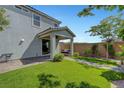 Expansive backyard featuring a covered patio with swing bench and a well-maintained lawn at 8349 Pollenzo Ave, Las Vegas, NV 89178