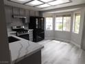 Bright eat-in kitchen boasts stainless steel appliances, quartz countertops, and modern gray cabinetry at 8640 Portofino Ct, Las Vegas, NV 89117