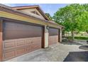 Spacious three-car garage with brown doors provides ample parking and storage, complementing the house's exterior at 8970 W Lone Mountain Rd, Las Vegas, NV 89129