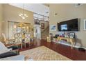 Open-concept living and dining area with high ceilings, wood floors, and staircase to the upper level at 916 Bob Barney Ct, North Las Vegas, NV 89086