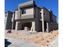 Modern two-story home featuring stucco exterior, open garage, and contemporary architectural details at 9997 River Corral St, Las Vegas, NV 89166