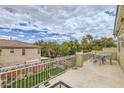 Enjoy outdoor dining on this large patio with iron railing overlooking the grassy backyard at 10798 Muscari Way, Las Vegas, NV 89141